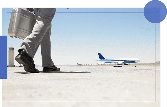 Two men standing on a runway with an airplane in the background.