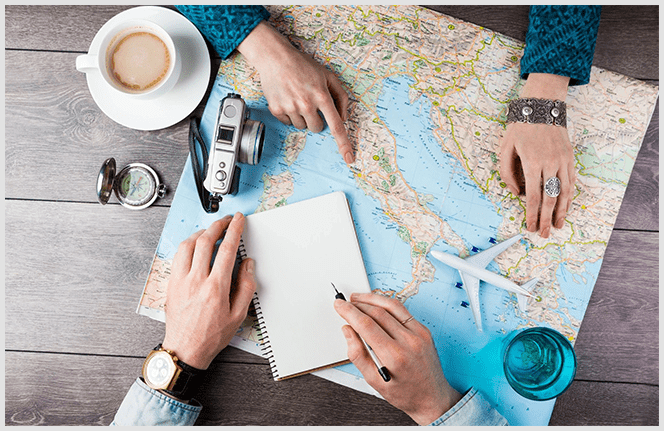 Two people are sitting at a table with a map and coffee.